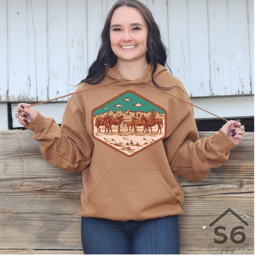 Woman standing smiling wearing a sweatshirt decorated with a Snappy 6 Co western screen print transfer